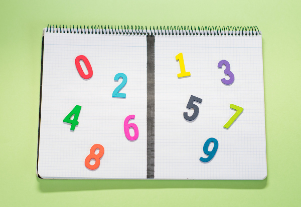 Números coloridos divididos sobre as folhas de um caderno para indicar quais são os pares e os ímpares.