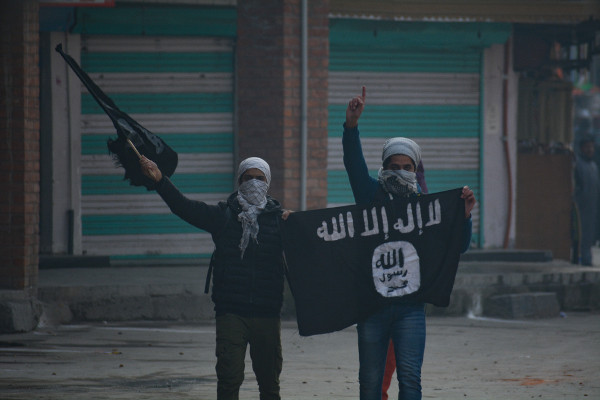 Homens segurando bandeiras do Estado Islâmico.