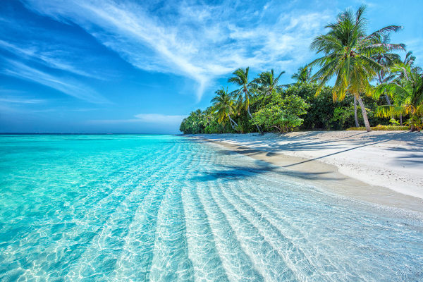 Imagem de uma praia tropical no Oceano nas Ilhas Maldivas.