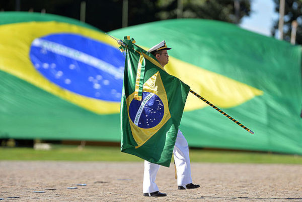 Militar desfilando com a Bandeira do Brasil, uma forma de comemorar o Dia da Bandeira.