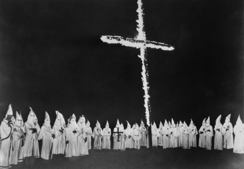 Membros da Ku Klux Klan e cruz em chamas.